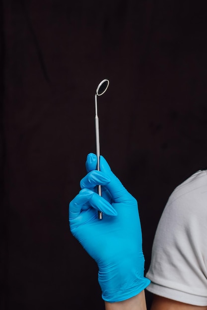 Foto tandheelkundige spiegel voor de mondholte in de handen van een chirurg