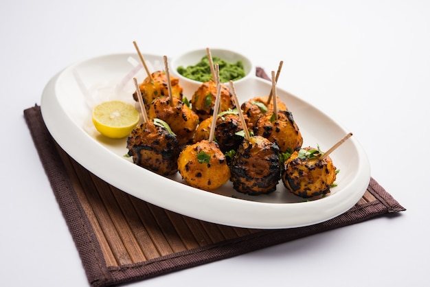 Tandoori aloo are roasted potatoes with Indian spices. It's a party appetiser served with green chutney. selective focus