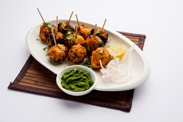 Tandoori aloo are roasted potatoes with Indian spices. It's a party appetiser served with green chutney. selective focus