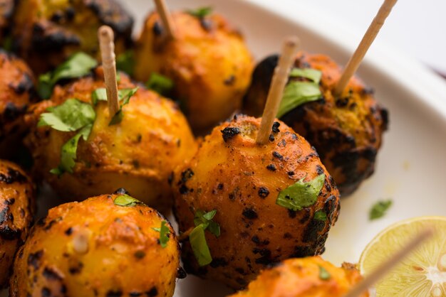 Tandoori aloo are roasted potatoes with Indian spices. It's a party appetiser served with green chutney. selective focus