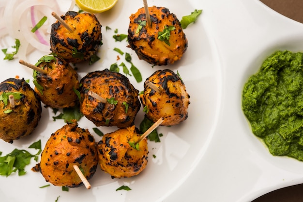 Tandoori aloo are roasted potatoes with indian spices. it's a party appetiser served with green chutney. selective focus