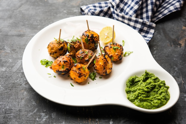 Tandoori aloo zijn geroosterde aardappelen met Indiase kruiden. Het is een feestelijk voorgerecht geserveerd met groene chutney. selectieve focus