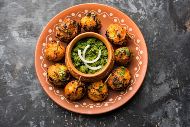 Tandoori aloo zijn geroosterde aardappelen met Indiase kruiden. Het is een feestelijk voorgerecht geserveerd met groene chutney. selectieve focus