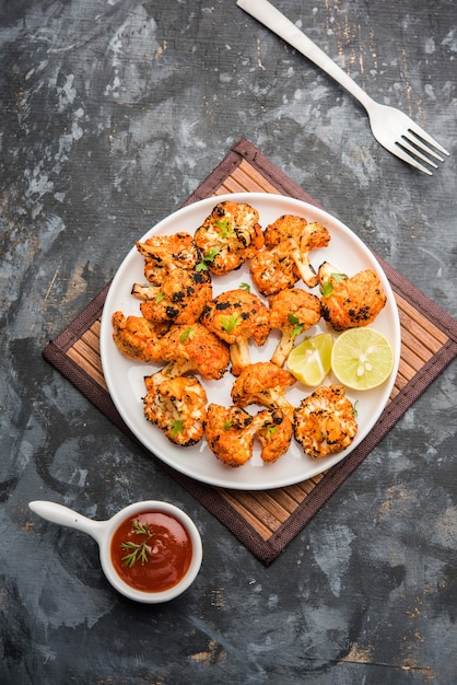 Tandoori Gobi of Geroosterde bloemkool Tikka is een droog gerecht gemaakt door bloemkool te roosteren in de oven, Tandoor. Het is populair voorgerecht uit India. geserveerd met ketchup. selectieve focus