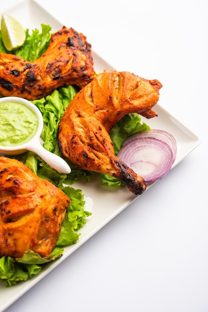 Tandoori kip is een kipschotel bereid door kip te roosteren gemarineerd in yoghurt en kruiden in een tandoor of een klei-oven, geserveerd met ui en groene chutney