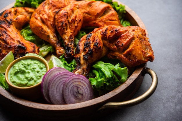 Tandoori kip is een kipschotel bereid door kip te roosteren gemarineerd in yoghurt en kruiden in een tandoor of een klei-oven, geserveerd met ui en groene chutney