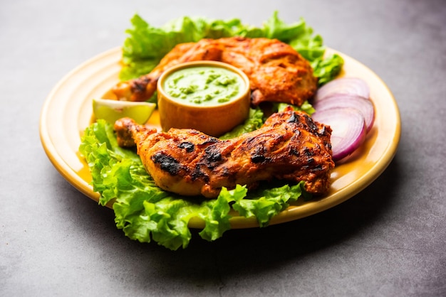 Tandoori kip is een kipschotel bereid door kip te roosteren gemarineerd in yoghurt en kruiden in een tandoor of een klei-oven, geserveerd met ui en groene chutney