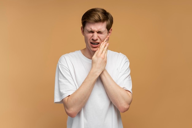 Tandproblemen Portret van een ongezonde man die op een zere wang drukt