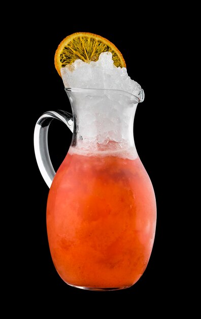 Tangerine lemonade in glass jug on dark background