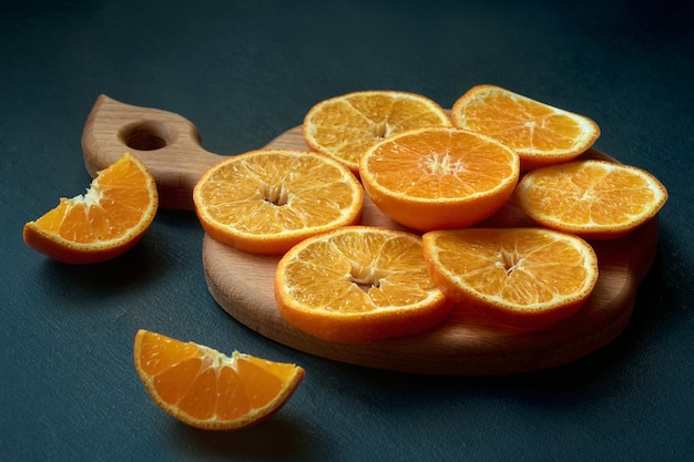 Tangerine or mandarin fruit sliced on a wooden board