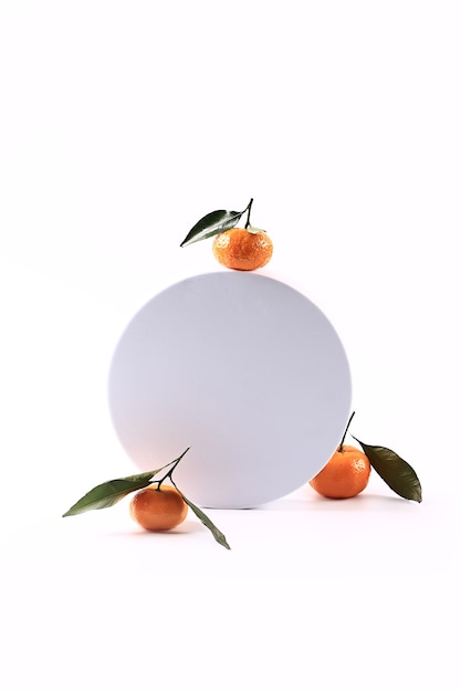 Tangerine on a white round podium. Soft selective focus. Winter festive background.