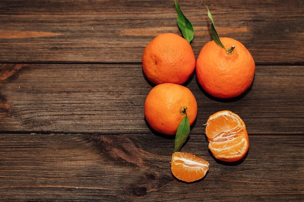 Tangerines on the background of a wooden brown table with boards