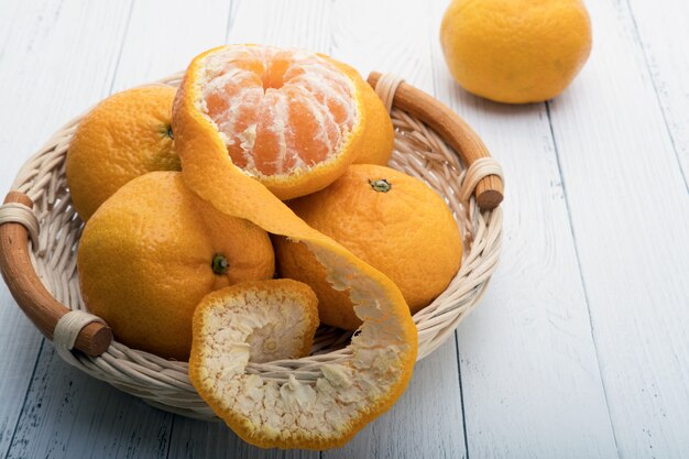 tangerines in a basket on white wooden boards