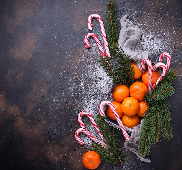 Tangerines and candy cane. Christmas background