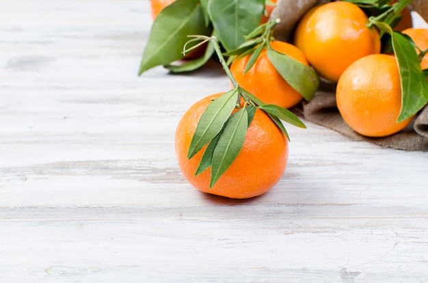 Tangerines clementine with leaves on a wooden table. 