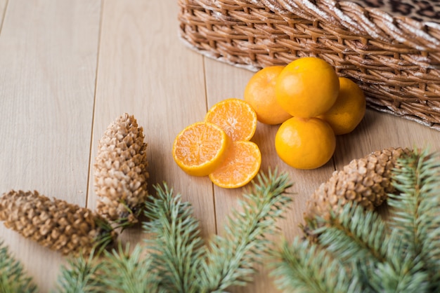 Tangerines, mandarins with christmas tree branches on wooden background. Copy space.