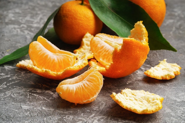 Tangerines oranges mandarins clementines citrus fruits with leaves  on gray cement background