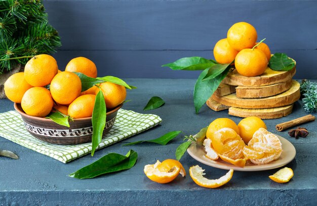 tangerines on a plate citrus slices on a wooden background tree and green leaves