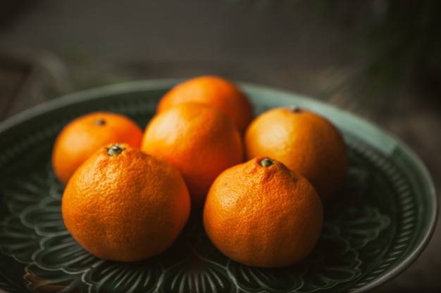 Tangerines and tree branches on wood table. Mandarine fruits