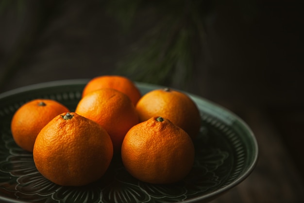 Tangerines and tree branches on wood table. Mandarine fruits