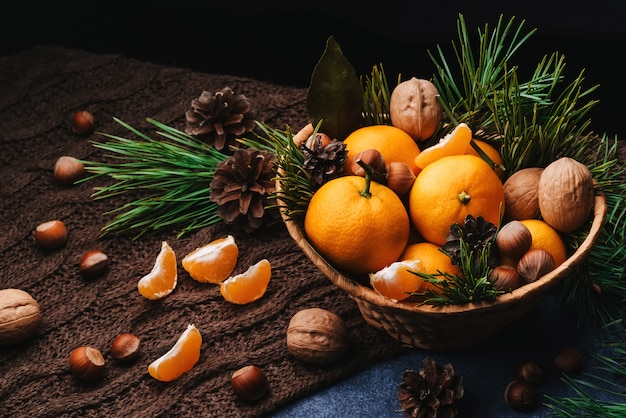 Tangerines, walnuts and hazelnuts decorated with pine cones