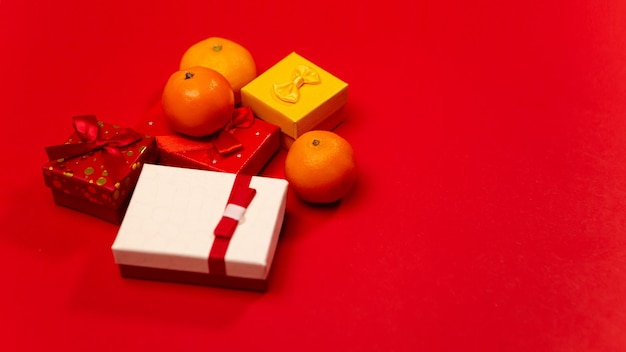 Tangerines with gifts on red background