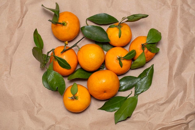 Tangerines with leaves on crumpled paper Beautiful fruits from above Lots of citrus fruits