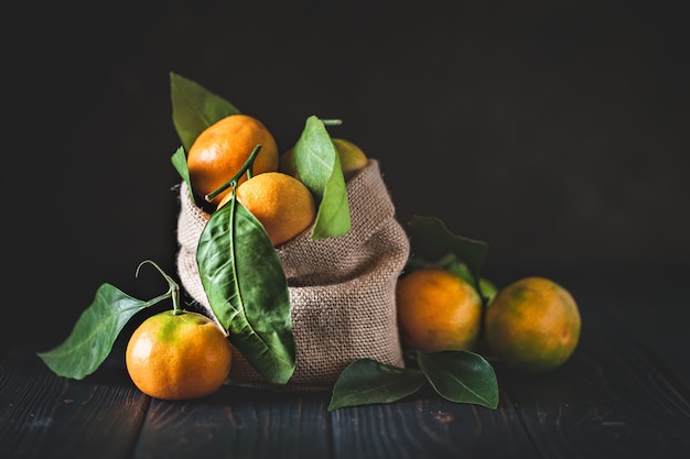 Tangerines with leaves on an old fashioned country table. Selective focus. Horizontal.