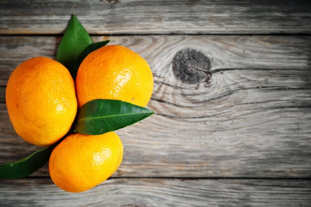 Tangerines with leaves on an old fashioned country table