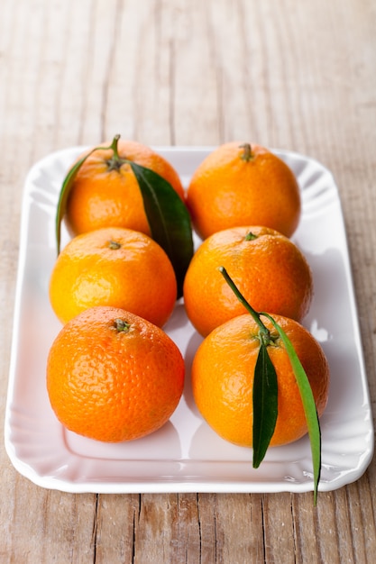 Tangerines with leaves in plate