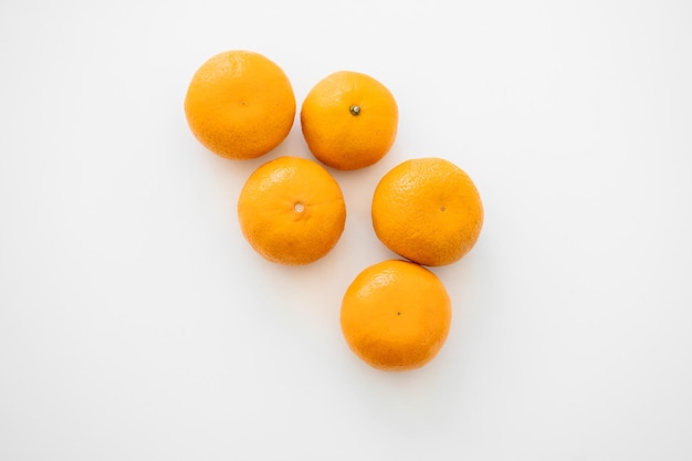 Tangerines with leaves and slices on white background