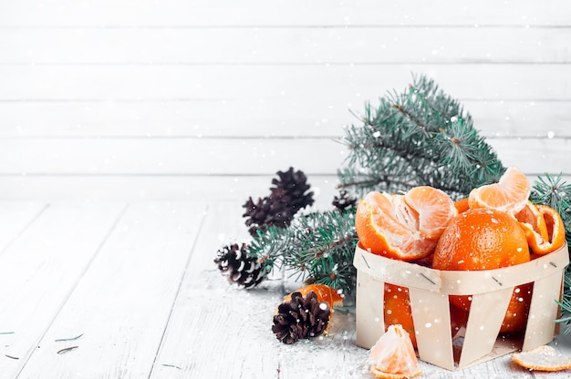 Tangerines with leaves on wooden table.