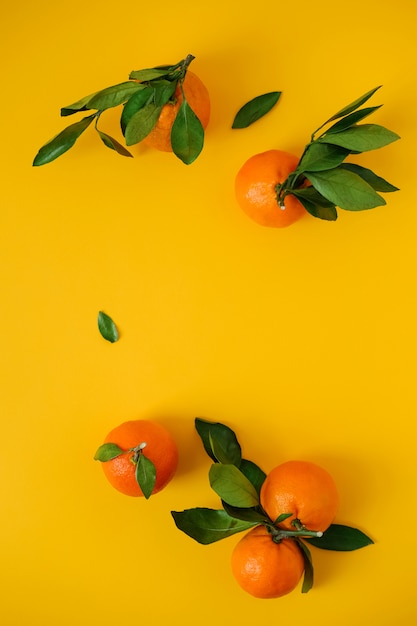 Tangerines on yellow surface top wiew. Flat lay.