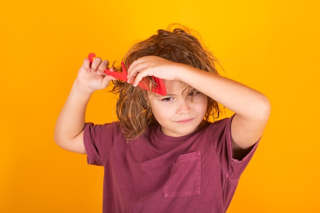 Tangled kids hair child with curly hair hold hairbrush or comb healthy hair kid brushing unruly