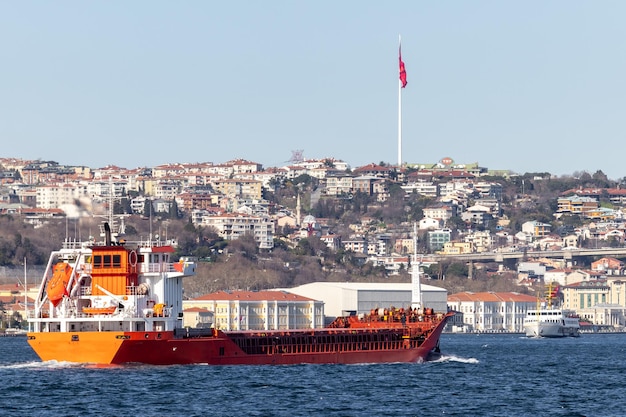 La nave cisterna passa attraverso il bosforo con il ponte sul bosforo a istanbul turchia o lo stretto del bosforo di turkiye che collega l'europa all'asia nave cisterna a istanbul turchia