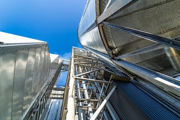 Tanks en landbouwsilo's van graanliftopslag. Buitenkant van het gebouw van de laadfaciliteit. Van onderaf bekijken.