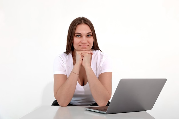 Foto ragazza abbronzata con un portatile su uno sfondo bianco freelance remote work mockup