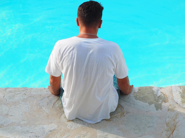 Tanned man in a hotel resting near the swimming pool