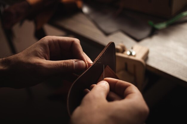 Photo tanner sews with threads makes leather purse diy instruction eco production entrepreneur