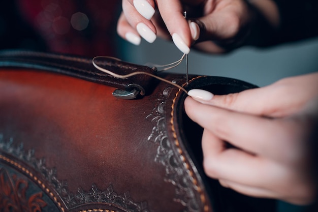 Tanner woman making leather goods on workshop Working process of leather craftsman