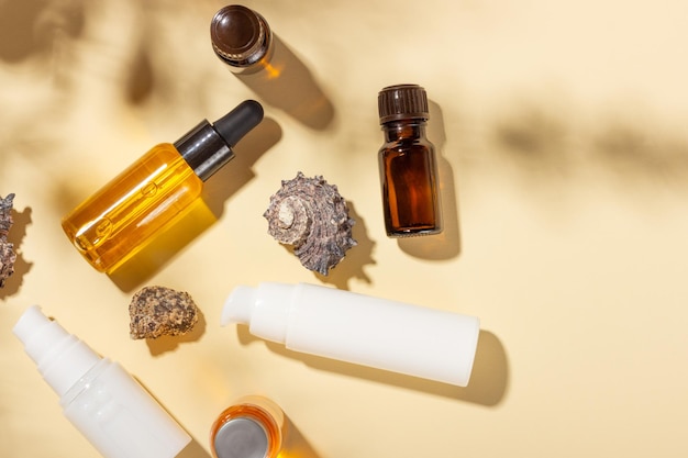 Tanning oil A set of cosmetics next to seashells in the sunbeams on a pink background Cosmetics for sun protection