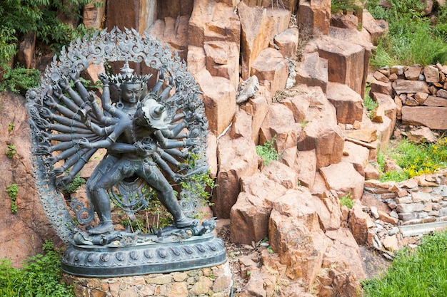 Foto statua di divinità tantriche in abbraccio rituale situata in un giardino di montagna