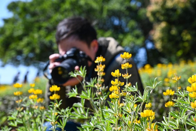 Taoyuan taiwan feb 23 2020 un uomo tiene in mano una macchina fotografica mentre fotografa fiori di lupino perenni