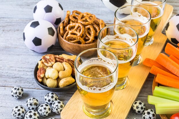 Tapbier en zoute snacks op tafel voor een voetbalfeest.