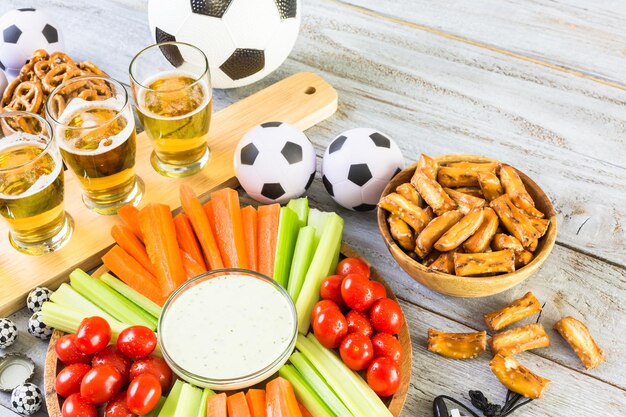 Tapbier en zoute snacks op tafel voor een voetbalfeest.