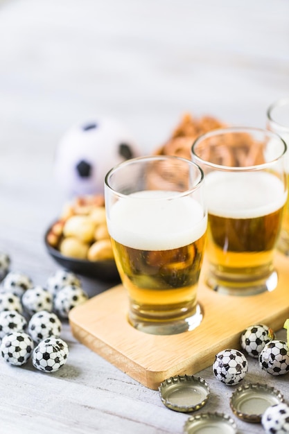 Tapbier en zoute snacks op tafel voor een voetbalfeest.