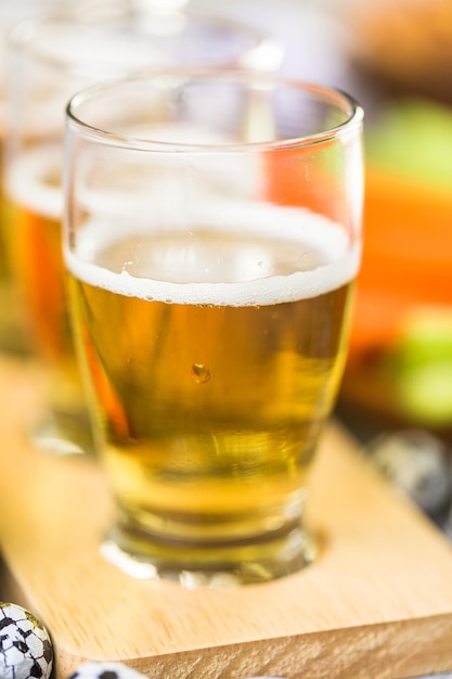 Tapbier en zoute snacks op tafel voor een voetbalfeest.