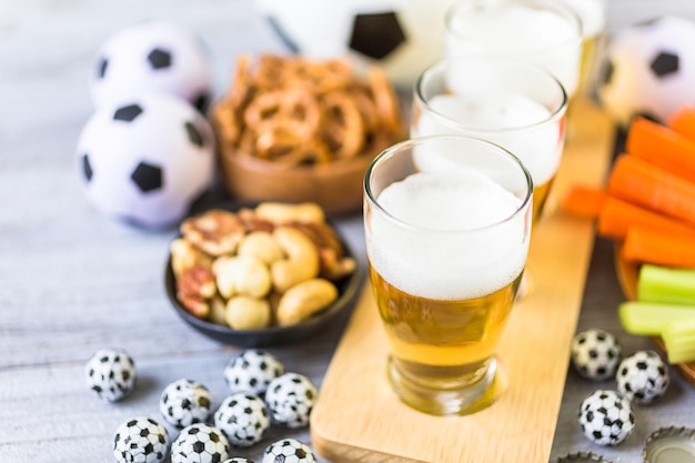 Tapbier en zoute snacks op tafel voor een voetbalfeest.