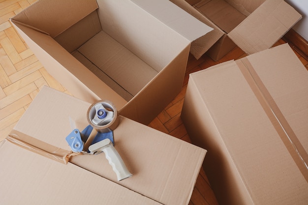 Tape dispenser sealing a shipping cardboard box