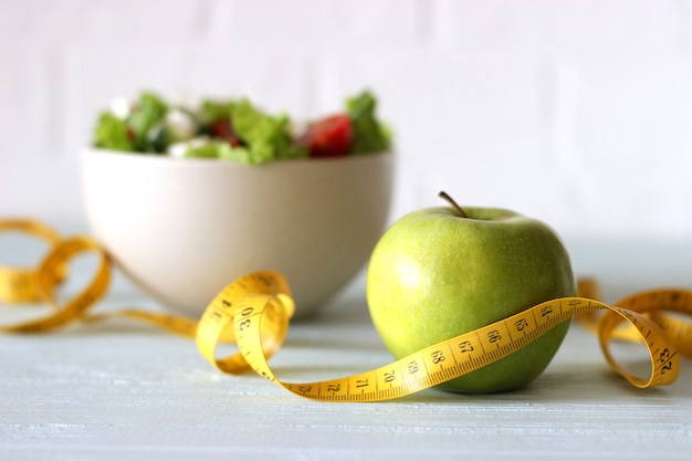 Tape and lettuce on a light background slimming diet healthy food